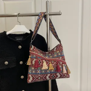 Boho ethnic woven shoulder bag with colorful geometric patterns and stylish tassels.