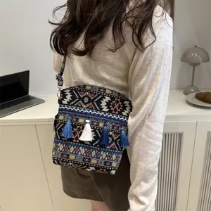 Vue détaillée du sac à bandoulière ethnique rétro avec motifs géométriques et pompons.