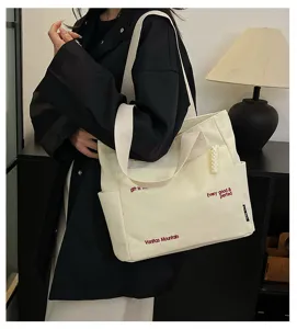 Canvas tote bag with stylish letters, large capacity for daily use, student casual shoulder bag.