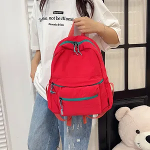Stylish red school backpack with contrast teal zippers and comfortable shoulder straps.
