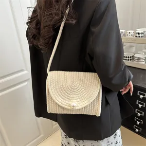 Handmade woven shoulder bag for women, chic straw envelope crossbody bag with pearl closure.