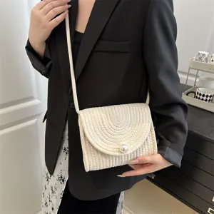 Woven crossbody bag detail, handmade cotton linen texture, elegant single pearl accent.