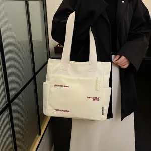 Large capacity canvas tote bag for women, stylish student shoulder bag for daily use.