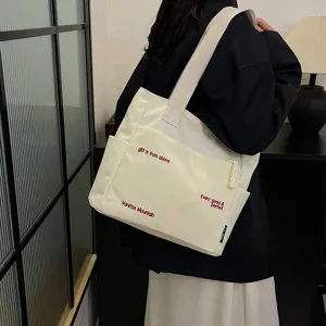 Canvas tote bag for women, large capacity shoulder bag with literary design and pockets.