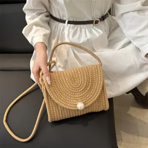 Woven straw shoulder bag with pearl clasp, stylish handmade crossbody handbag for women.