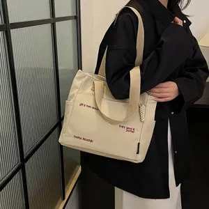 Canvas tote bag for women, large capacity shoulder bag with embroidered letter design for students.