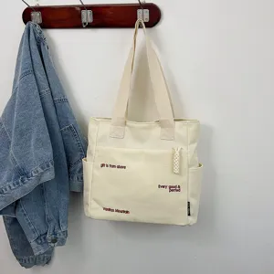 Canvas tote bag detailed view, showing spacious capacity and front pocket design.