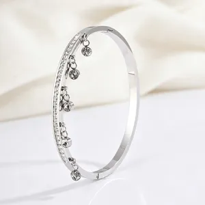 Detailed view of the elegant titanium steel bangle featuring sparkling pave stones and dangling charms.