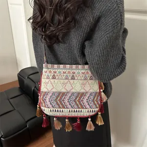 Borsa a tracolla con nappe in stile etnico dettaglio con motivo intrecciato e design.