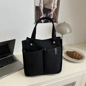 Schwarze Canvas Tragetasche mit mehreren Taschen, lässige Handtasche für Arbeit, Schule und Alltag.