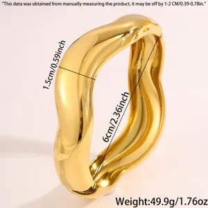 Close-up detail view of wide irregular gold-plated stainless steel wave design bangle bracelet.