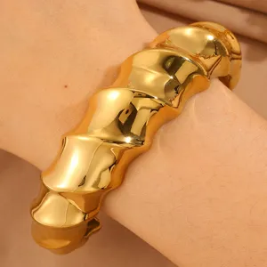 Chunky gold-plated statement cuff bracelet with irregular wavy design for women stylish wear.