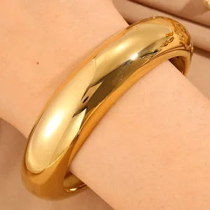 Wide gold metal cuff bracelet, modern polished open bangle for women, stylish stacking jewelry.