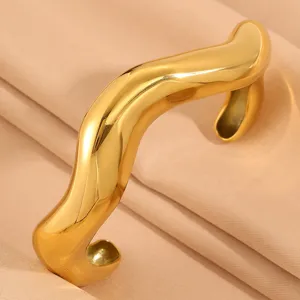 Gold irregular wave open cuff bracelet close-up detail shot, minimalist fashion jewelry design.