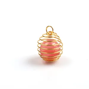 Detaillierte Nahaufnahme eines goldenen Drahtkäfig-Anhängers mit einem rosa Edelstein.