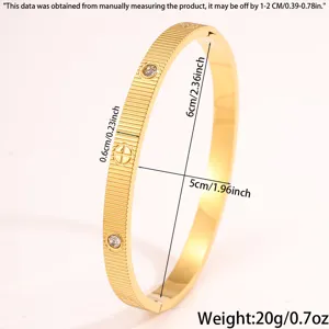 Goldfarbenes Titanstahl-Armband Detail mit Streifenstruktur, funkelnden Kristallen und Maßen.