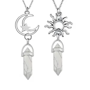Dettaglio della collana con ciondolo in cristallo sole luna e pilastri di pietra bianca.