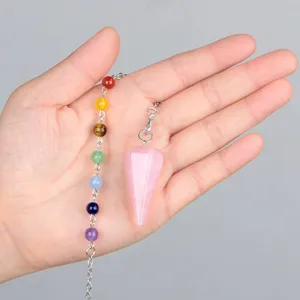 Detailaufnahme des Naturkristall-Hexagon-Pendels mit bunten Chakra-Perlen in Hand.