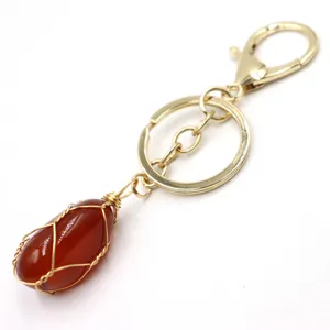 Wire-wrapped red stone crystal pendant keychain gold metal hardware detail view close up