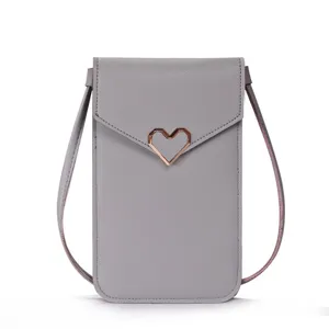 Detail shot of the grey mini crossbody phone bag highlighting the chic rose gold heart clasp.