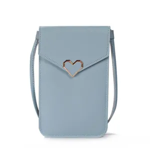 Detail view of the light blue mini crossbody phone bag with chic metal heart clasp detail.