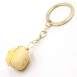 Natural stone wire wrapped keychain detail, gold color metal charm for bag and keys.