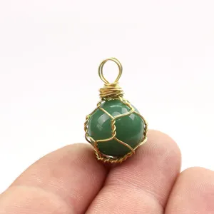 Detaillierte Nahaufnahme einer gruenen Kristallkugel mit handgemachter goldener Drahtwicklung.