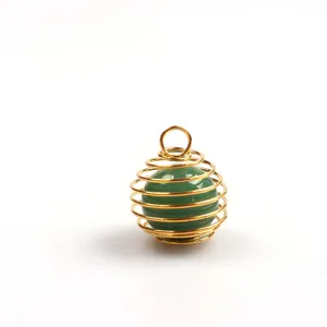 Nahaufnahme Detail des goldenen Drahtfederkäfig-Anhängers mit einer grünen Edelsteinkugel.