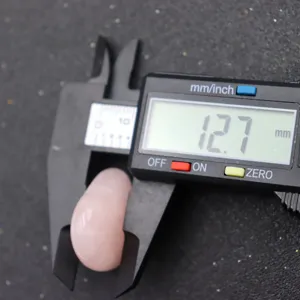 Rose quartz crystal gemstone detail showing size measurement with digital caliper tool.