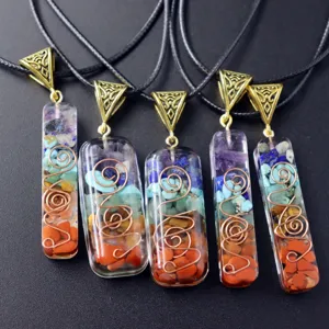 Primer plano detallado de collares con colgantes de resina y cristales chakra con hilo de cobre.