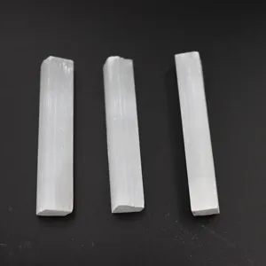 Close-up detail of natural white selenite crystal sticks, raw stone columnar mineral display.