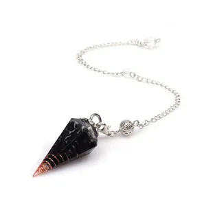 Detail close-up of a crystal dowsing pendulum with a black resin hexagonal cone and copper spiral.