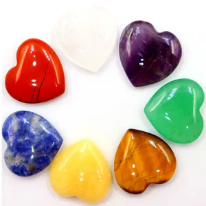 Gros plan de cœurs en cristal coloré polis disposés en cercle sur fond blanc propre et uni.