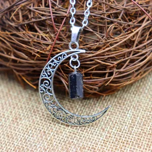 Primer plano de collar colgante de media luna de plata vintage con piedra de cristal negro.