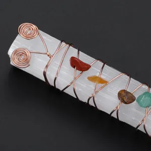 Natural selenite crystal wand wrapped with copper wire and colorful chakra gemstone chips detail.