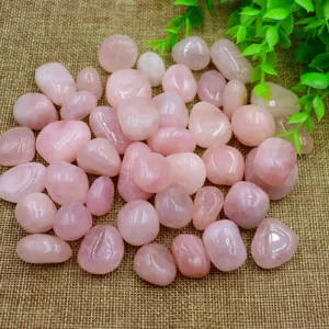 Close-up detail shot of natural tumbled pink rose quartz crystal stones for aromatherapy.