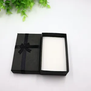 Boîte cadeau de bijoux en papier noir avec nœud papillon noir pour bagues et colliers.