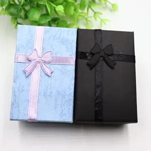 Vue détaillée de petites boîtes à bijoux cadeaux avec nœuds, idéales pour bagues et colliers.