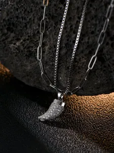 Detailed shot of double layer stainless steel men necklace with dazzling cubic zirconia horn pendant.