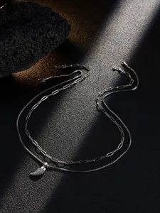Detailed view of stainless steel double layer horn pendant necklace set for men with zirconia.