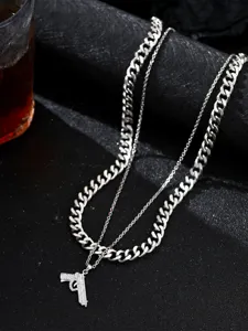 Primer plano de cadena de doble capa de acero inoxidable para hombre con colgante de pistola.
