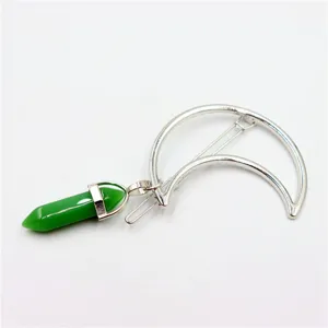 Close-up detail of green crystal hexagonal pillar pendant on silver crescent moon hair clip.