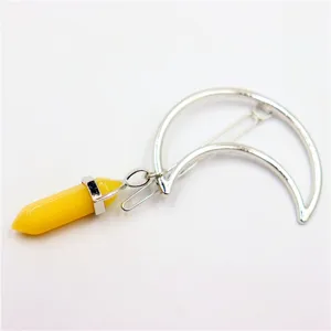 Detail view of a stylish crescent moon hair clip featuring a yellow crystal hexagonal pillar.