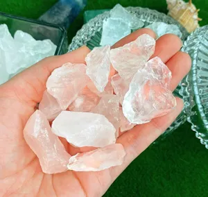 Nahaufnahme von rohen rosa Quarzkristallen in der Hand gehalten für die wunderschöne Heimdekoration.