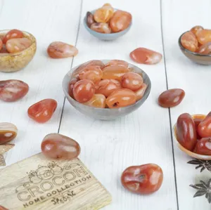 Detailed close-up of polished red agate stones arranged in bowls for home decor and crystal healing.