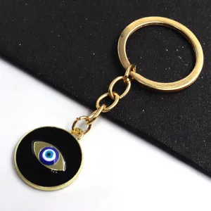 Porte-clés en alliage doré avec pendentif traditionnel œil turc sur fond émaillé.