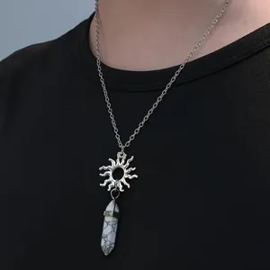 Gros plan détail du pendentif collier rétro soleil et colonne hexagonale de cristal.
