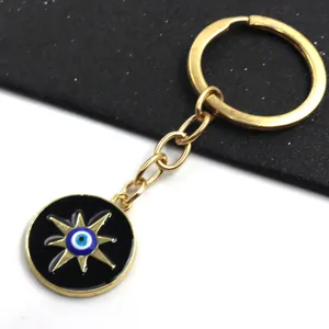 Détail rapproché du porte-clés en métal avec un œil turc et un pendentif étoile doré.