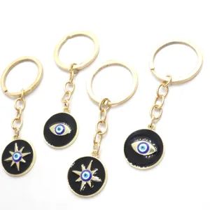Porte-clés en alliage métallique doré avec émail noir, motif mauvais œil et étoile, lot de quatre.