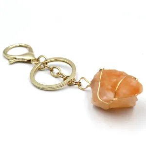 Llavero de cristal crudo natural con cierre de metal dorado y colgante de piedra.